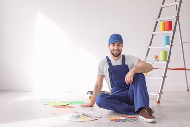 Photo of Male decorator with color palettes indoors