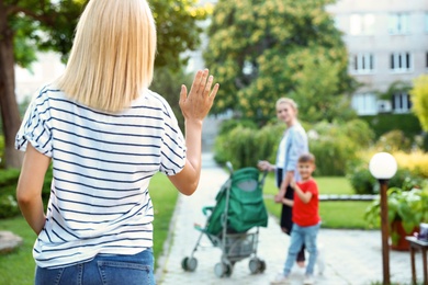 Photo of Mother leaving children with teen nanny in park. Space for text