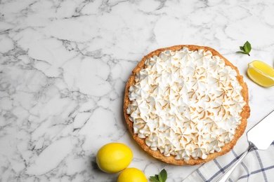 Photo of Flat lay composition with delicious lemon meringue pie on white marble table, space for text