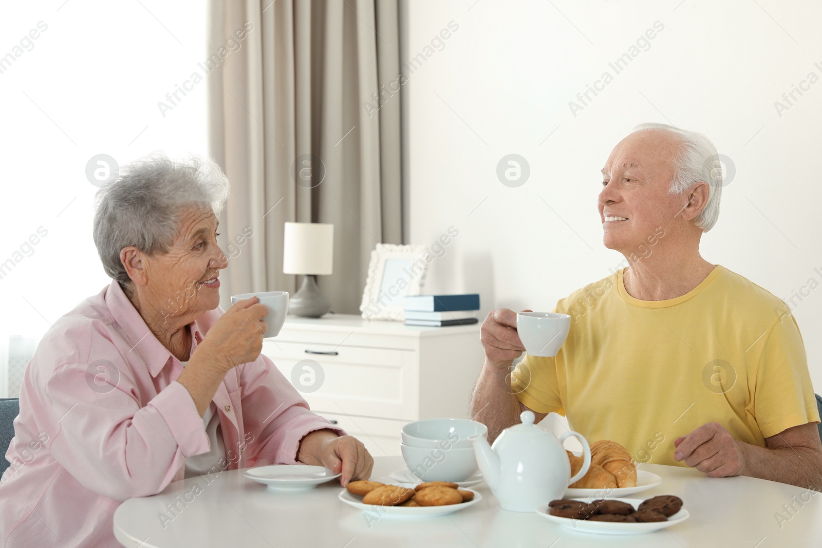 Photo of Elderly people having breakfast at nursing home. Assisting senior people