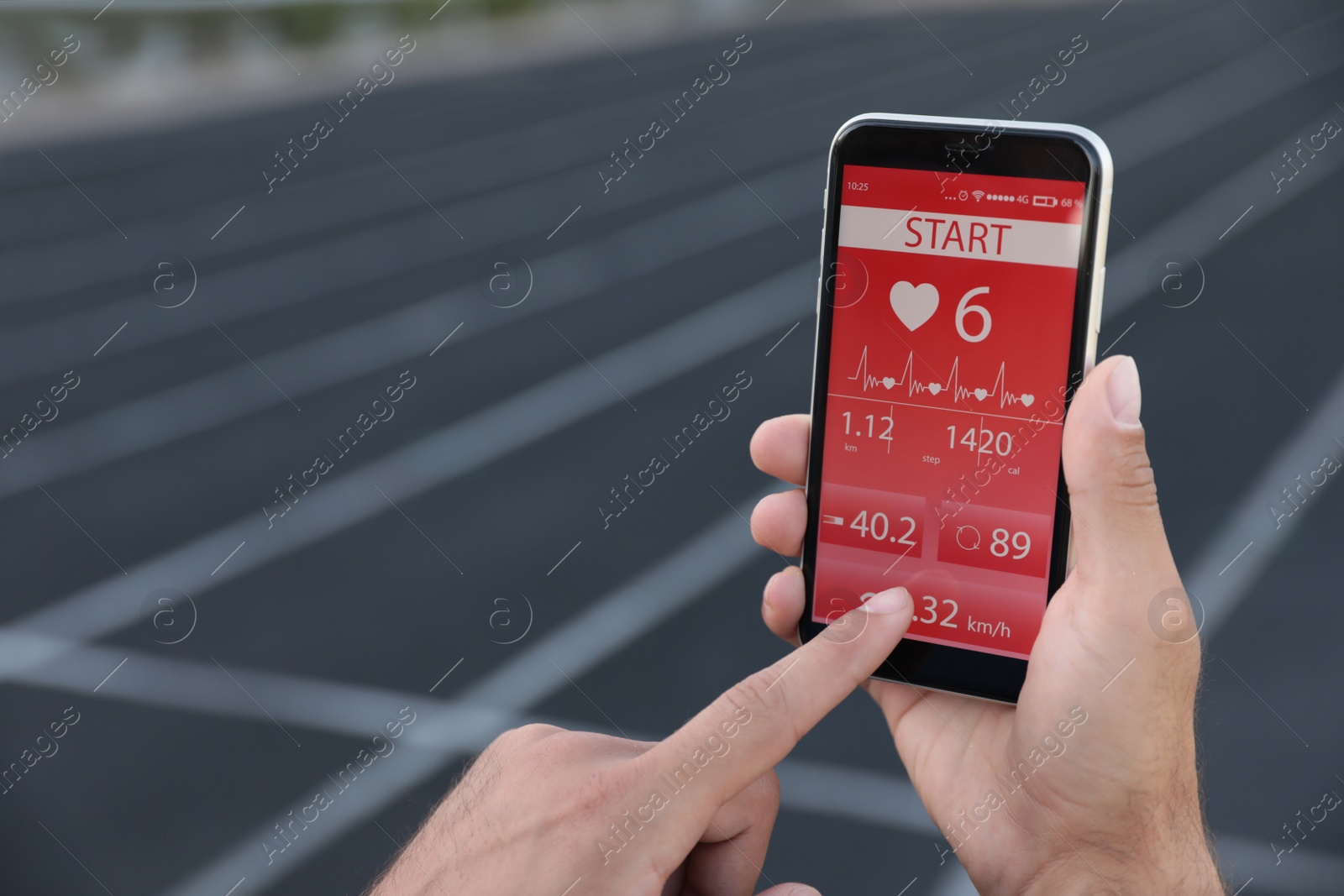 Photo of Man using fitness app on smartphone at stadium, closeup