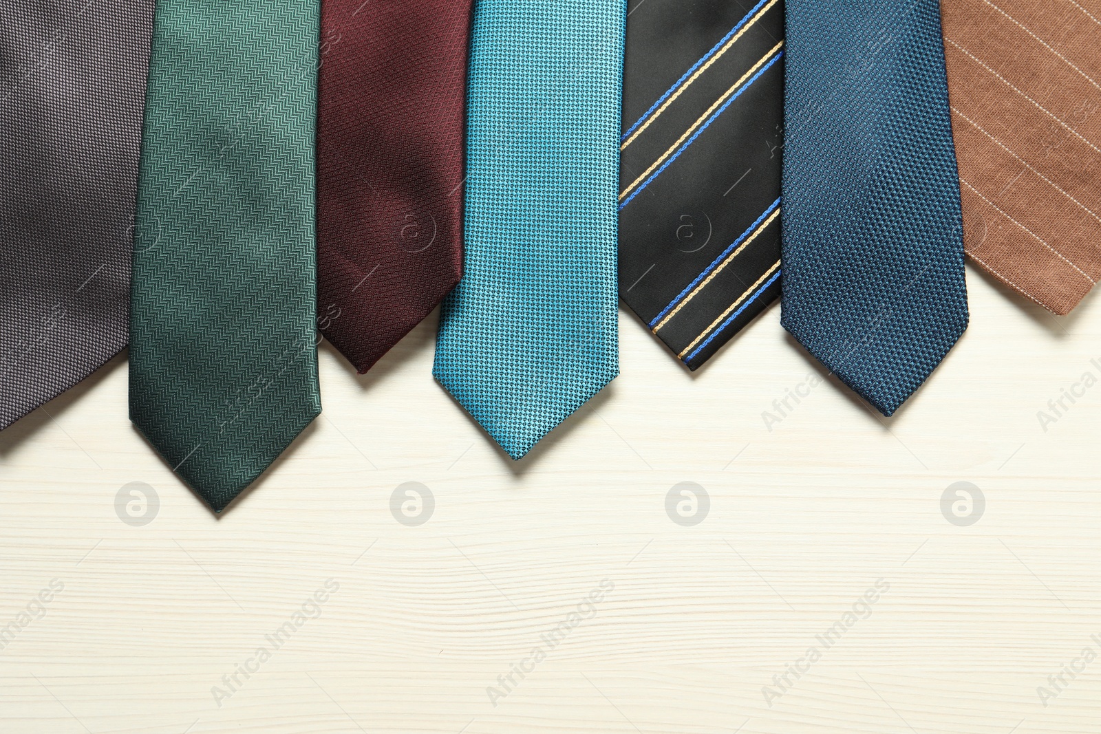 Photo of Different neckties on white wooden table, flat lay. Space for text