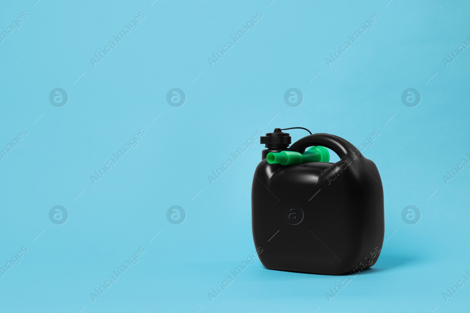 Photo of New black plastic canister on light blue background. Space for text