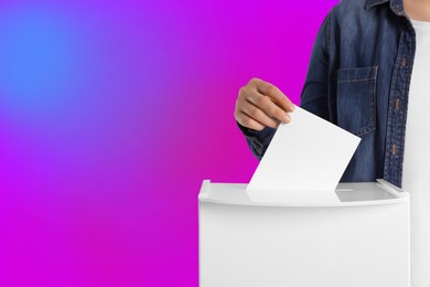 Woman putting her vote into ballot box on color background, closeup