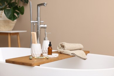Photo of Different personal care products and accessories on bath tub in bathroom