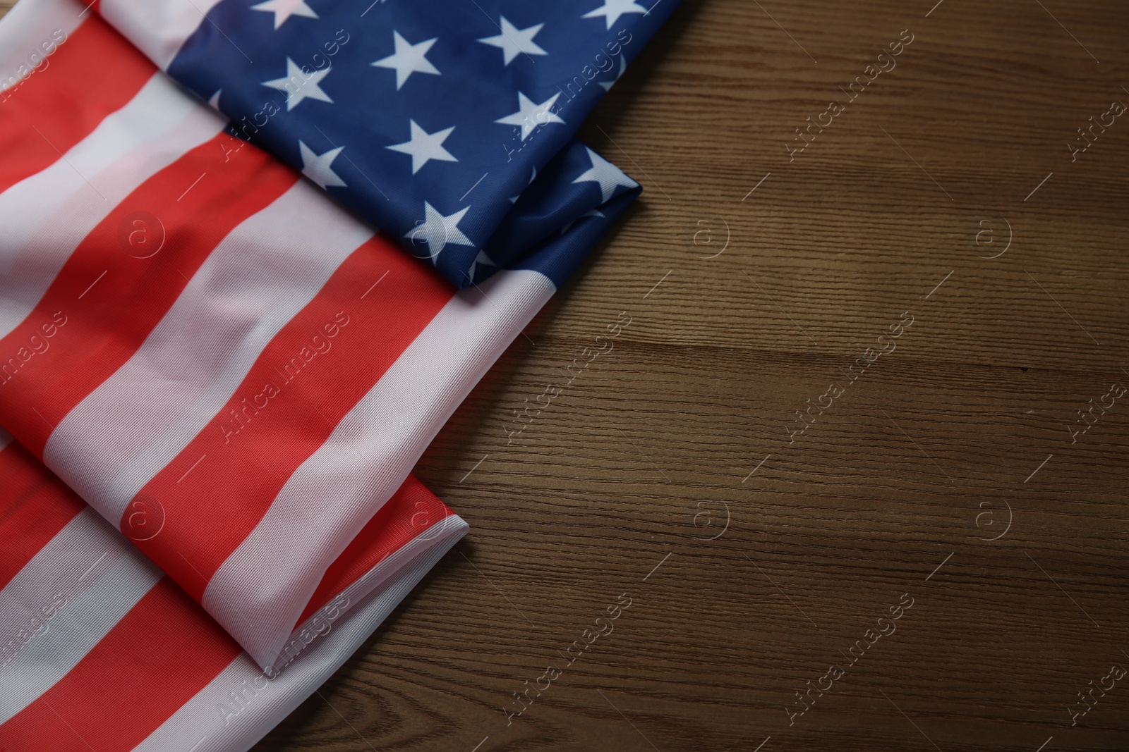 Photo of Flag of USA on wooden table, top view. Space for text