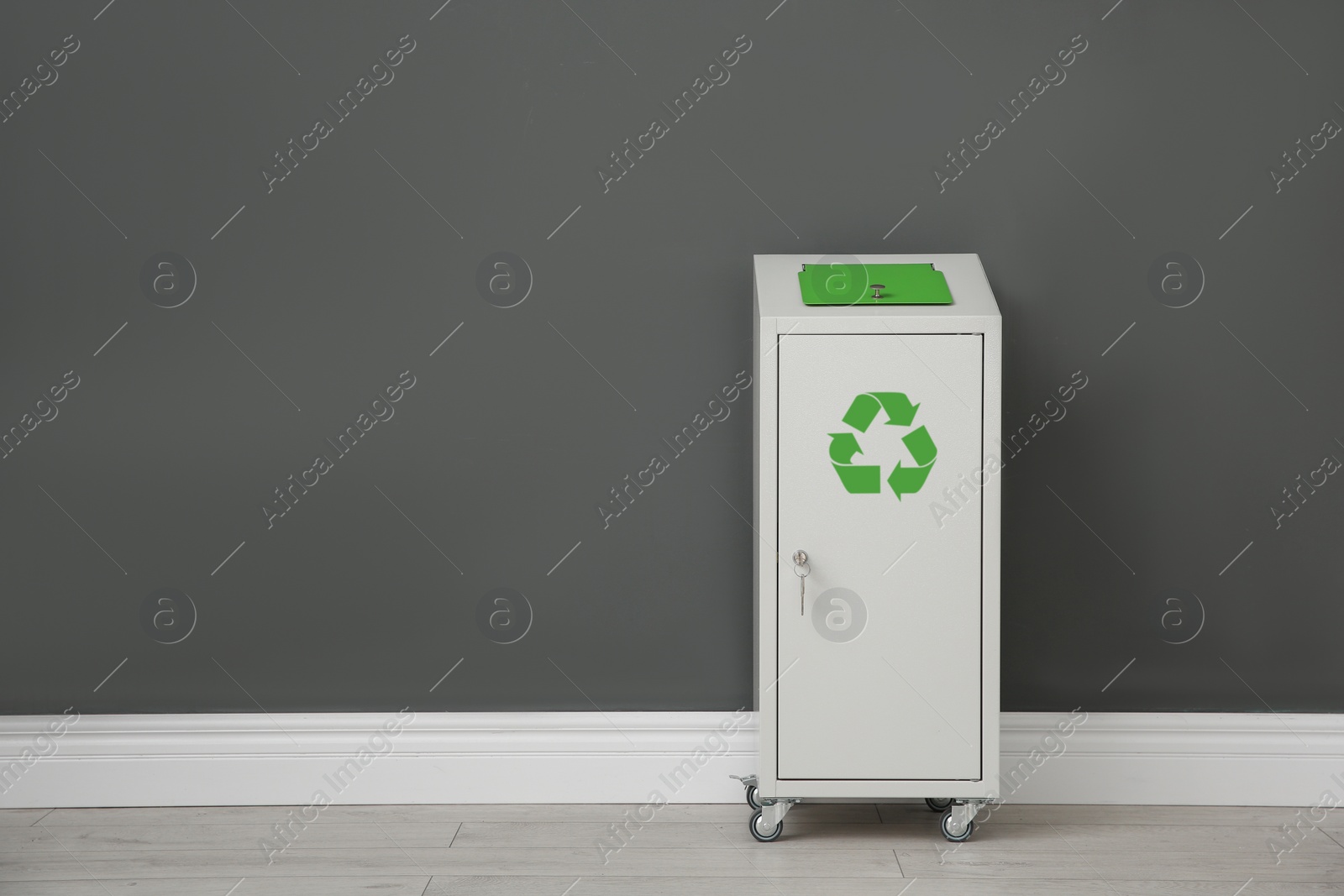 Photo of Metal bin near color wall, space for text. Waste recycling