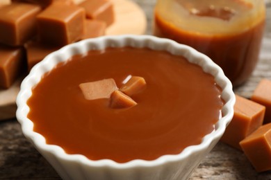 Tasty salted caramel with candies on table, closeup