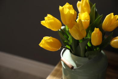 Photo of Beautiful sunlit bouquet with yellow tulips on wooden table, closeup