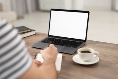 Photo of Young man writing down notes during webinar at table in room, closeup