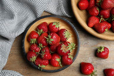 Photo of Delicious ripe strawberries on wooden table, flat lay