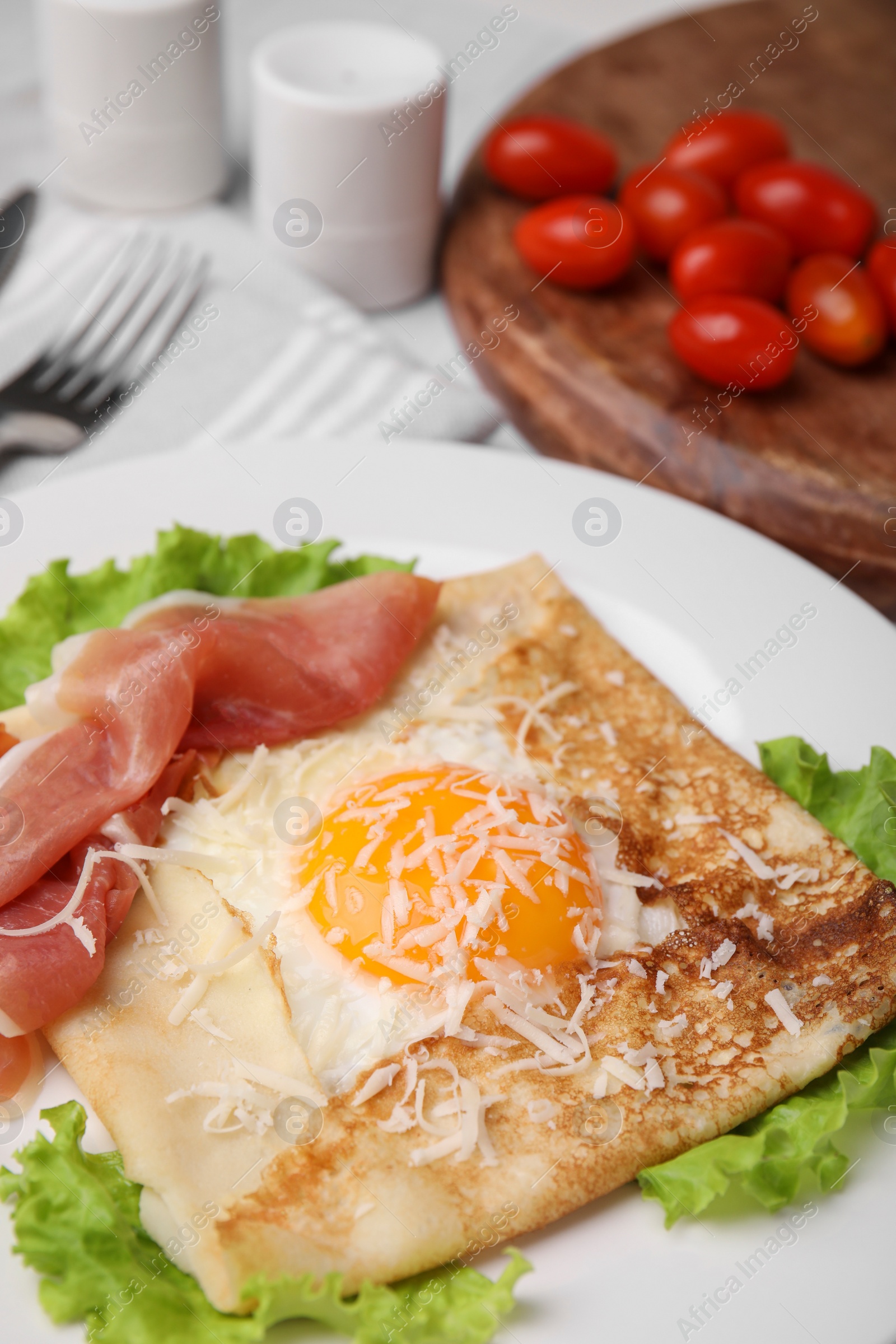 Photo of Delicious crepe with egg on table, closeup. Breton galette