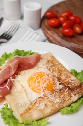 Delicious crepe with egg on table, closeup. Breton galette