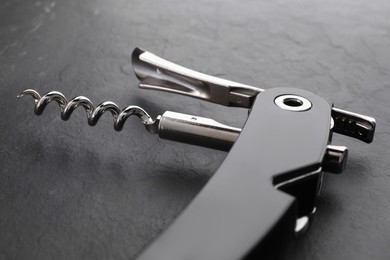 One corkscrew (sommelier knife) on grey textured table, closeup