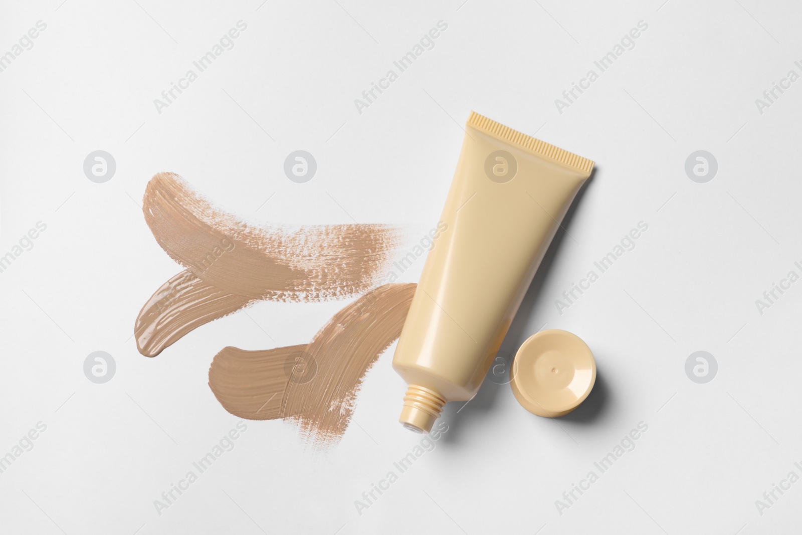 Photo of Foundation and swatches on white background, top view