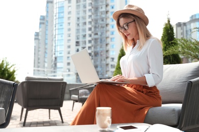 Photo of Beautiful woman using laptop at outdoor cafe