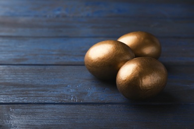 Photo of Golden eggs and space for text on wooden background. Pension concept