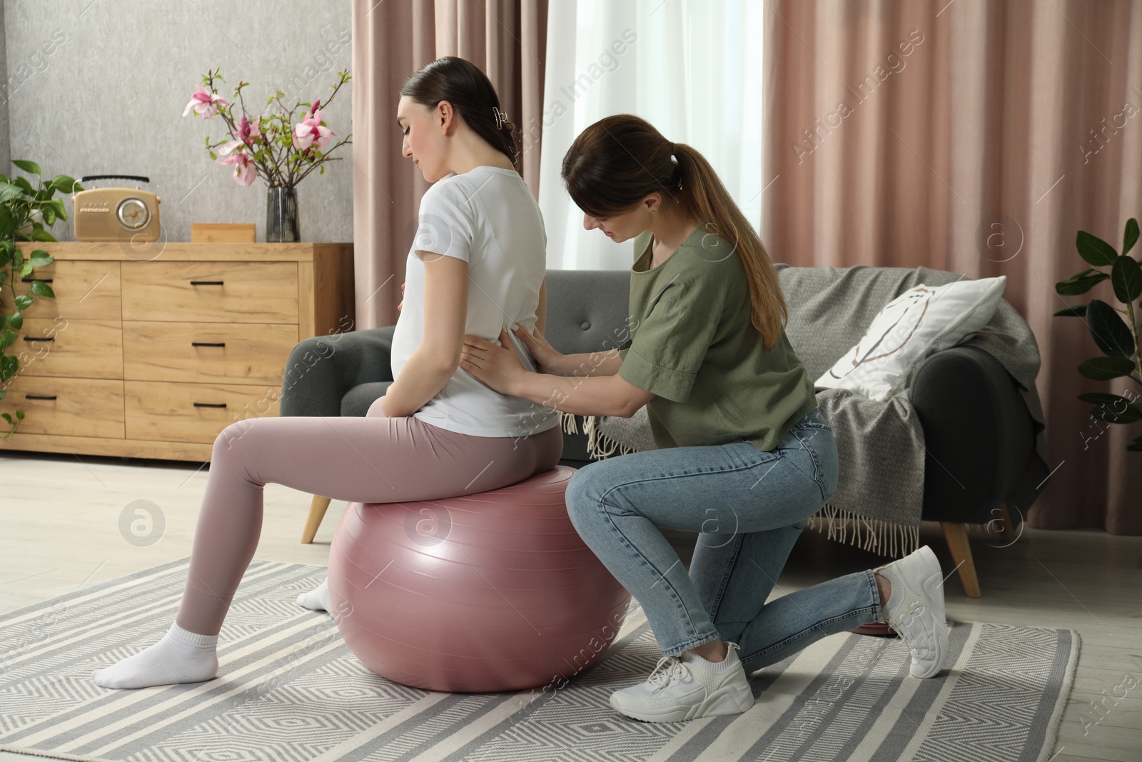 Photo of Doula massaging pregnant woman at home. Preparation for child birth