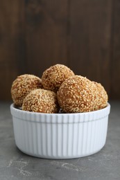 Bowl of delicious sesame balls on grey table