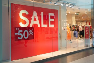 Photo of Siedlce, Poland - July 26, 2022: Sale sign on red stand in fashion store at shopping mall. Seasonal discount offer