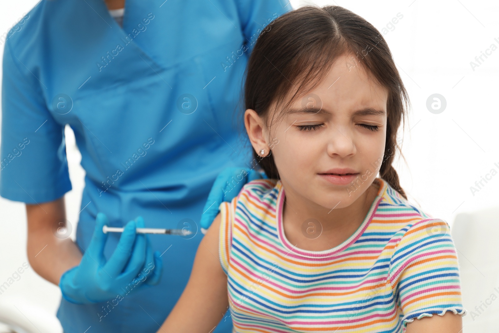 Photo of Doctor vaccinating little child in modern clinic