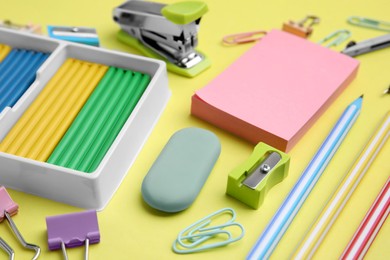 Photo of Many different school stationery on pale yellow background, closeup. Back to school