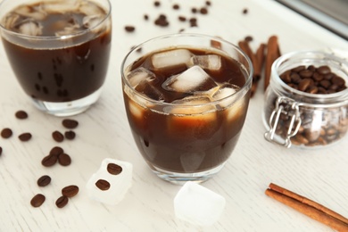 Glass of coffee drink with ice cubes on table