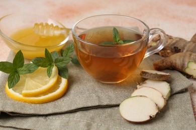 Photo of Tea with mint, honey, lemon and ginger on table