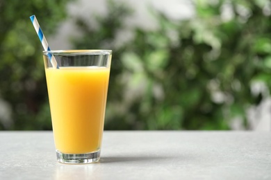 Photo of Glass of orange juice on light table. Space for text