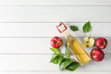 Flat lay composition with delicious apple cider on white wooden table, space for text