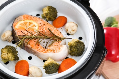 Salmon steak with garnish in multi cooker, closeup