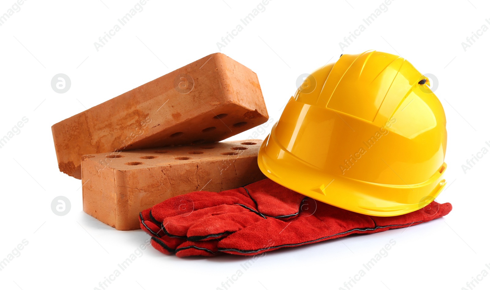 Photo of Hard hat, gloves and bricks on white background. Construction industry