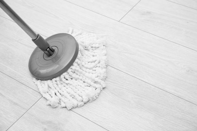 Photo of Cleaning dirty parquet floor with mop indoors. Space for text