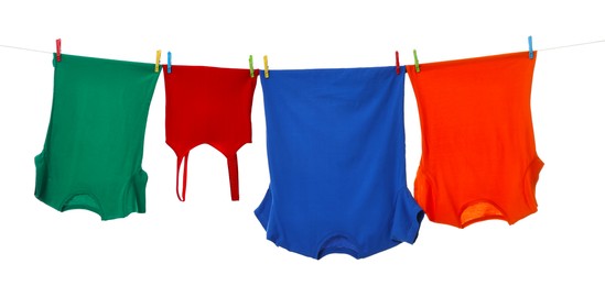 Different clothes drying on laundry line against white background