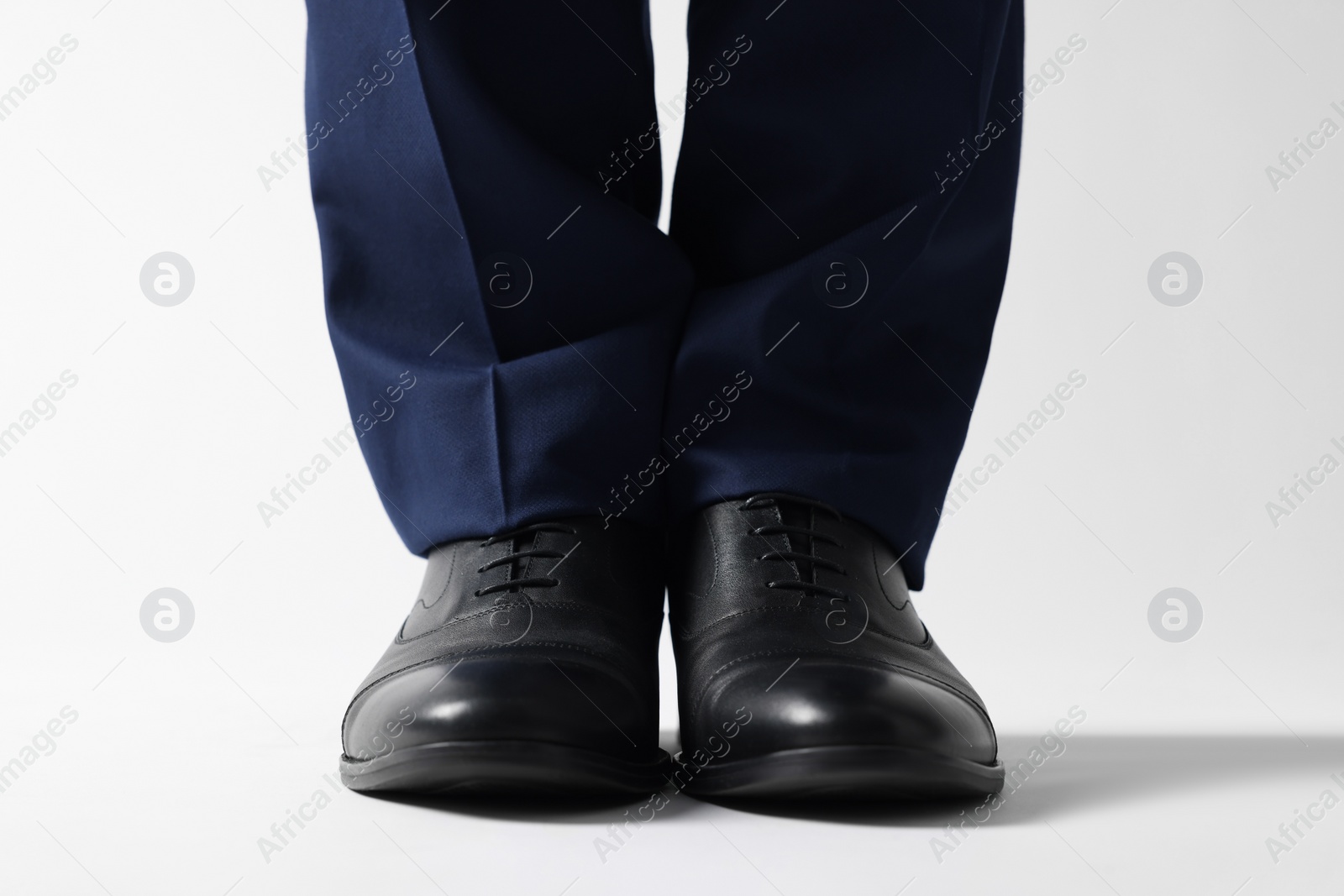 Photo of Businessman in leather shoes on white background, closeup