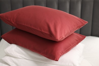 Photo of Stack of red and white pillows on bed