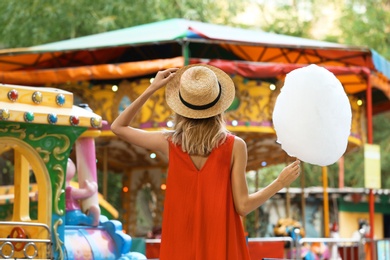 Young woman with cotton candy in amusement park