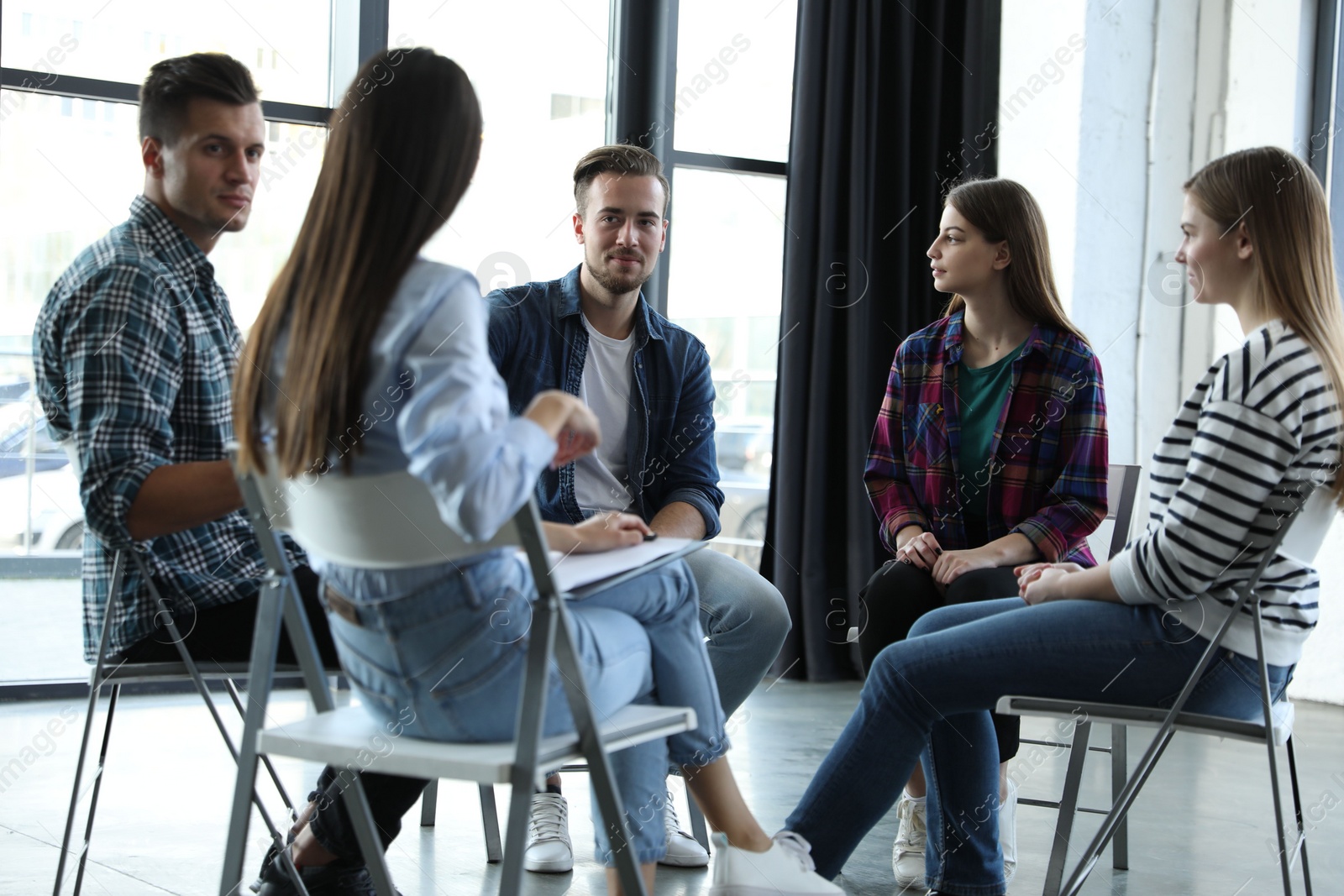 Photo of Psychotherapist working with patients in group therapy session indoors