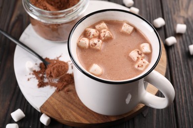 Cup of aromatic hot chocolate with marshmallows and cocoa powder served on table, closeup