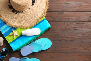 Flat lay composition with beach accessories on wooden background. Space for text