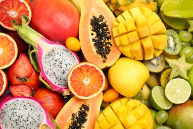 Many different delicious exotic fruits as background, top view