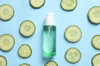 Photo of Flat lay composition with fresh cucumber slices and tonic in bottle on color background