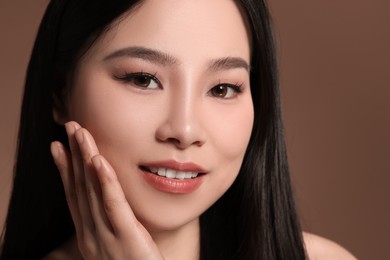 Portrait of beautiful woman on brown background, closeup