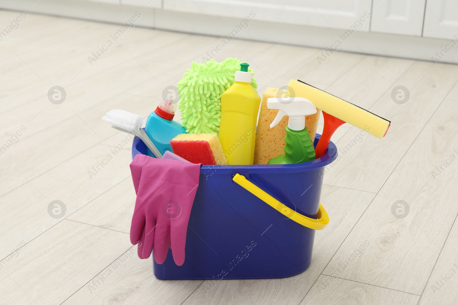 Photo of Different cleaning supplies in bucket on floor