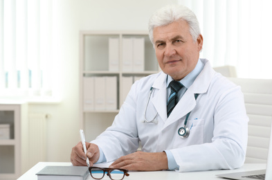 Photo of Portrait of senior doctor in white coat at workplace