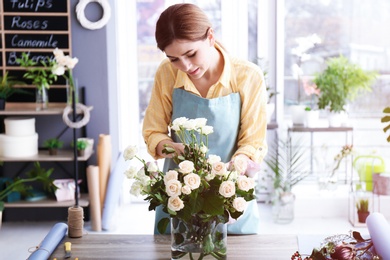 Photo of Female florist creating floral composition at workplace
