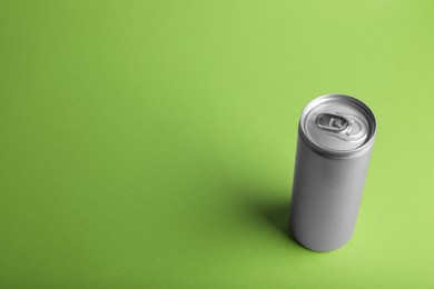 Can of energy drink on light green background. Space for text