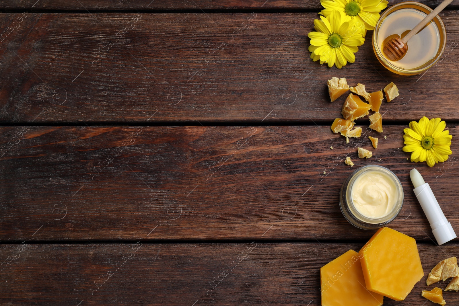 Photo of Flat lay composition with beeswax and cosmetic products on wooden table. Space for text