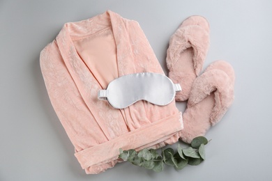 Photo of Flat lay composition with house slippers, sleeping mask and robe on light background