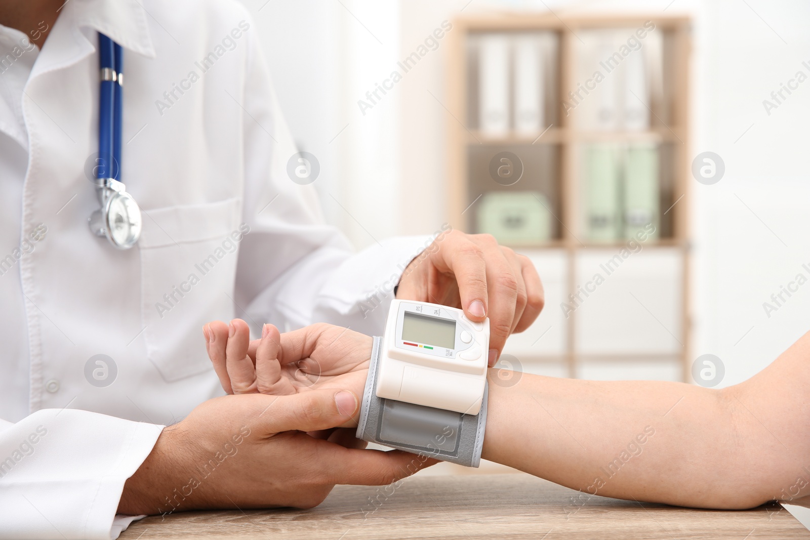 Photo of Doctor checking mature woman's pulse with medical device in hospital, closeup